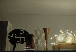 cerebro de cerámica entre instrumentos médicos antiguos y libros con guirnalda de luz